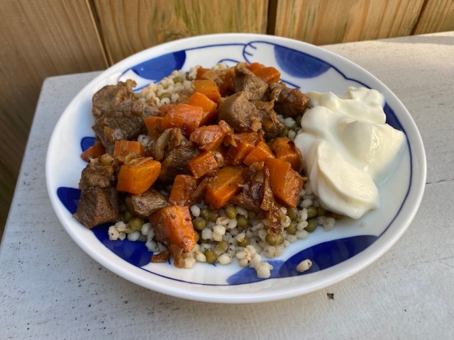 lamb and carrots on top of sorghum and mung beans